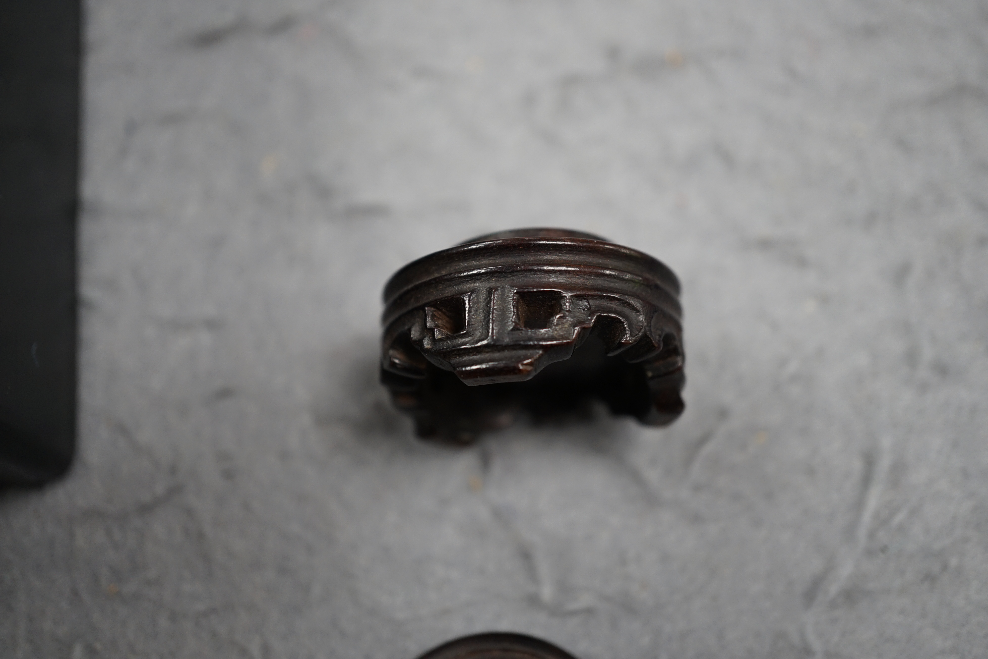 A Chinese jadeite archer's thumb ring, wood stand and cover, 19th century